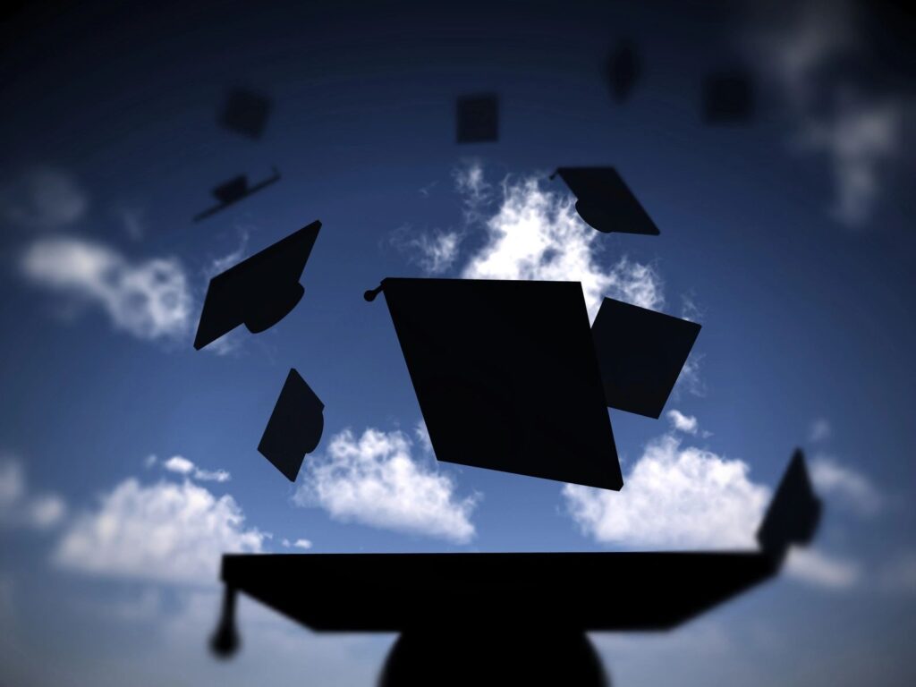 Graduation caps in air